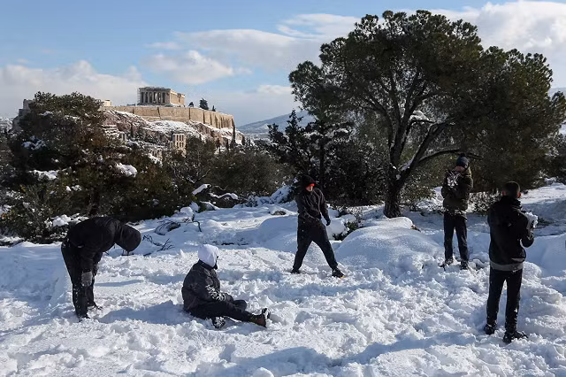 Thanh niên chơi đùa dưới tuyết trên Đồi Filopappou ở Athens, Hy Lạp.