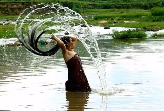  Hình ảnh người phụ nữ Thái gội đầu bên bờ suối - Ảnh: Sưu tầm 