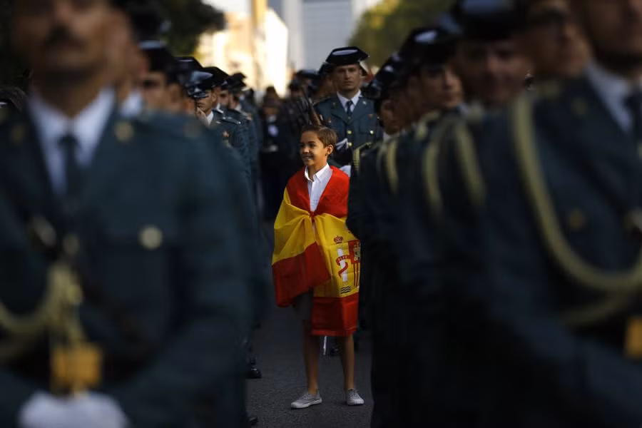 Cậu bé khoác lá cờ Tây Ban Nha chuẩn bị cho một cuộc diễu hành ở Madrid Cậu bé khoác lá cờ Tây Ban Nha chuẩn bị cho một cuộc diễu hành ở Madrid
