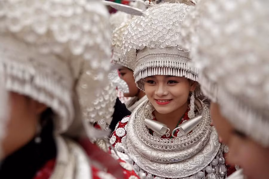 Những phụ nữ đang mặc trang phục truyền thống tham gia vào một cuộc diễu hành tại Gulong, Trung Quốc