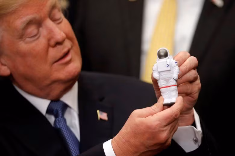 Tổng thống Donald Trump cầm món đồ chơi nhà du hành vũ trụ khi ông tham gia lễ ký kết về chính sách Không gian ở Nhà Trắng