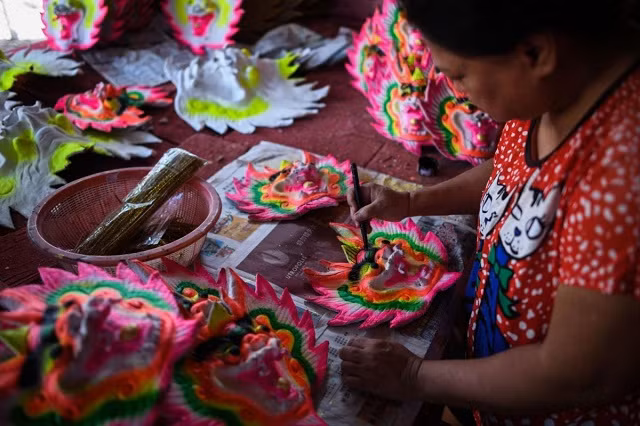 Một công nhân đang trang trí những con rồng để đặt những cây nhang khổng lồ tại một nhà máy ở Kubang Semang, Malaysia Một công nhân đang trang trí những con rồng để đặt những cây nhang khổng lồ tại một nhà máy ở Kubang Semang, Malaysia