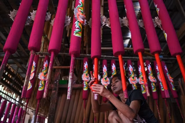 Một công nhân Malaysia đang trang trí những cây nhang khổng lồ Một công nhân Malaysia đang trang trí những cây nhang khổng lồ