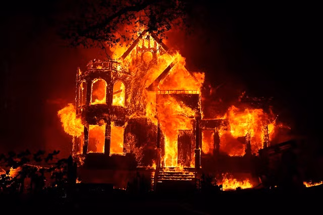 Một ngôi nhà chìm trong biển lửa trong đám cháy rừng ở St Helena, California, Hoa Kỳ. [Stephen Lam / Reuters]