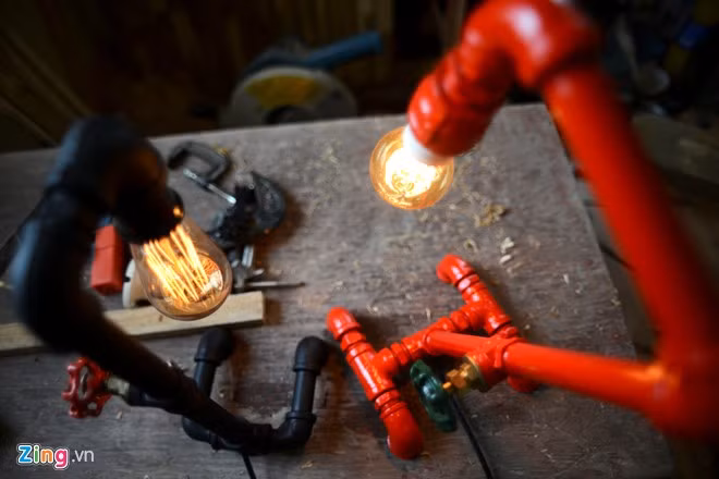 Sản phẩm của anh được làm từ vật liệu bỏ đi như ống nước cũ, gỗ thừa. Chàng trai biến đồ gỗ thừa, ống nước thành bóng đèn độc đáo
