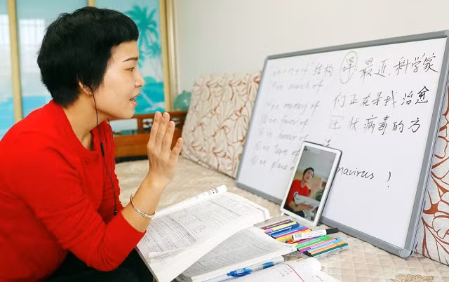Một GV tiếng Anh từ một trường trung học địa phương ở thành phố Thạch Gia Trang, tỉnh Hà Bắc của Trung Quốc, có một lớp học trực tuyến với học sinh ở nhà