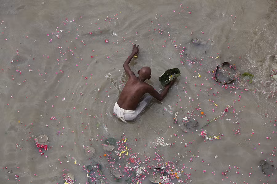 Một người đàn ông Hindu thực hiện nghi lễ ban phước cho các linh hồn tổ tiên ở sông Hằng, India