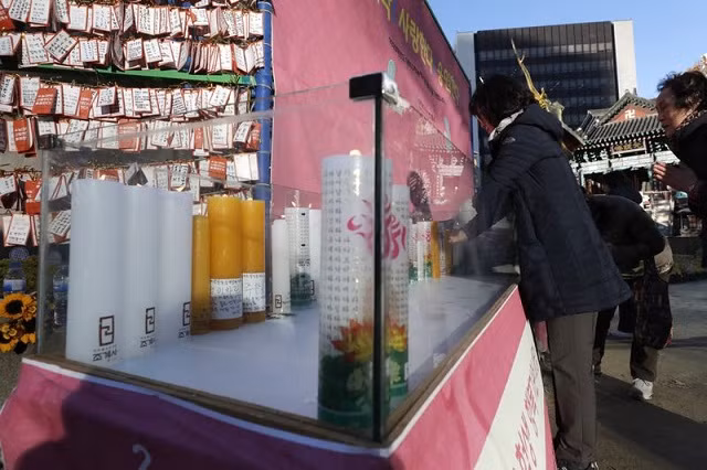 Một phụ huynh cầu cho con thi tốt tại Đền Jogye ở Seoul, Hàn Quốc. Một phụ huynh cầu cho con thi tốt tại Đền Jogye ở Seoul, Hàn Quốc.