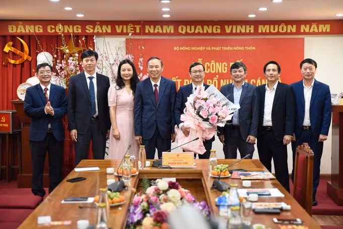 Thứ trưởng Phùng Đức Tiến tặng hoa chúc mừng Tổng Biên tập và Ban Biên tập Báo Nông nghiệp Việt Nam. (Ảnh: Tùng Đinh)