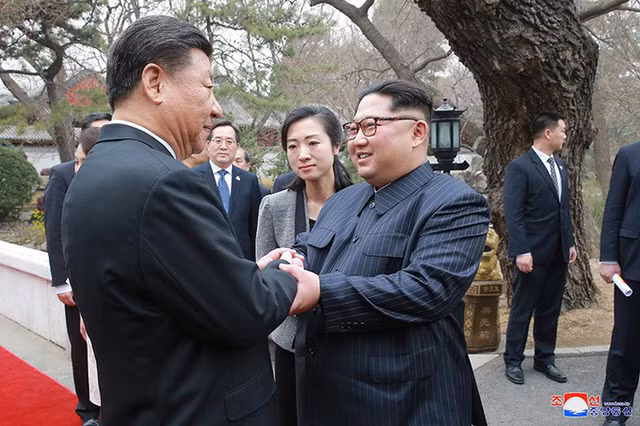Lãnh đạo Triều Tiên Kim Jong-un (phải) gặp chủ tịch Trung Quốc Tập Cận Bình trong chuyến thăm đầu tiên hồi tháng 3