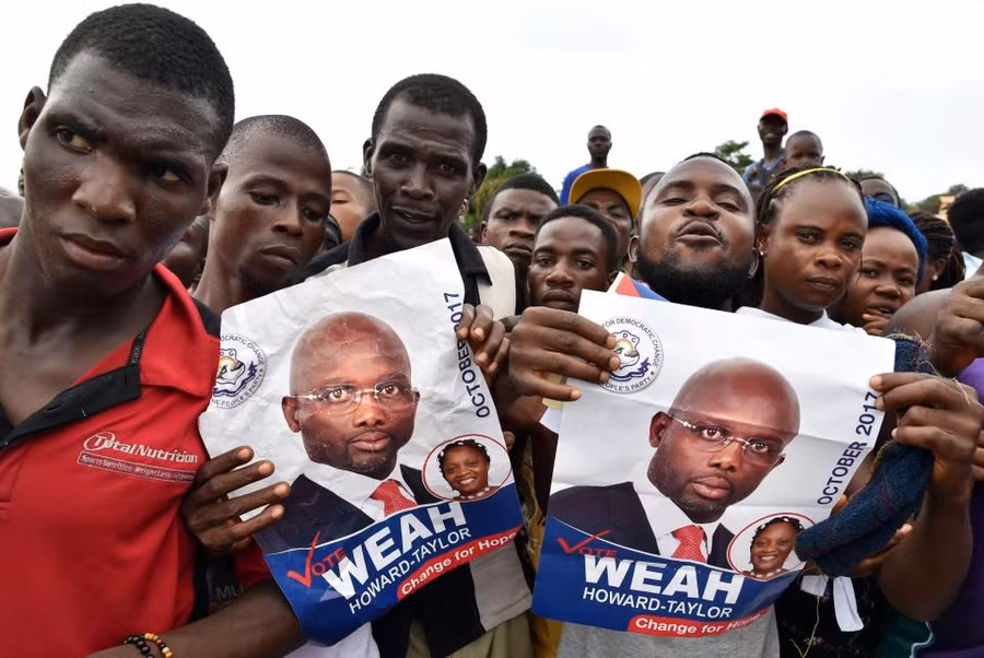 Những người vận động bầu cử George Weah cầm poster của ông