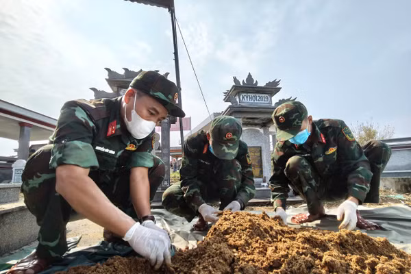 Lực lượng làm nhiệm vụ khai quật, cất bốc ngôi mộ liệt sĩ tập thể. Ảnh: Quang Cường Bộ CHQS Đà Nẵng