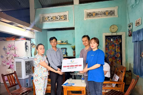 ThS Trần Thanh Trình (thứ 2, từ trái sang) – Bí thư Chi bộ Trường Cao đẳng Công nghệ Y - Dược Việt Nam trao học bổng cho sinh viên Trần Cẩm Vy (áo xanh). 