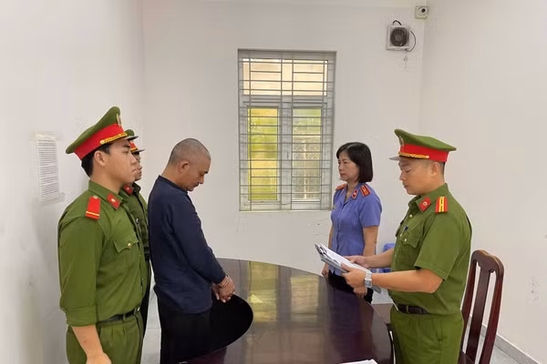 Cơ quan Công an tống đạt quyết định khởi tố vụ án, khởi tố bị can và lệnh bắt tạm giam với Huỳnh Khổng. Ảnh: CACC