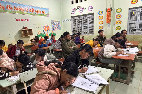 Các học viên lớp học xóa mù chữ chăm chú viết bài.