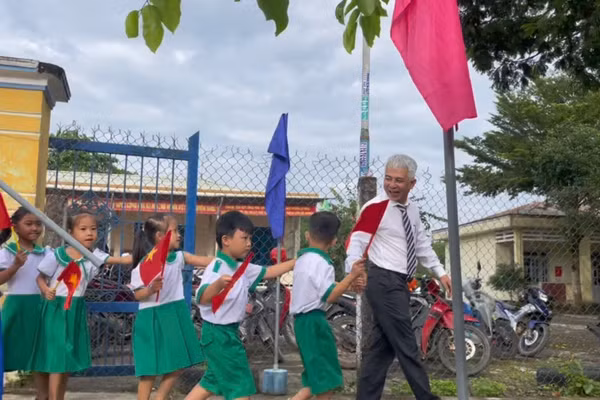 Ông Trần Bảo Tú - Hiệu trưởng Trường Tiểu học Nguyễn Bá Ngọc dắt học sinh lớp 1 vào trường.