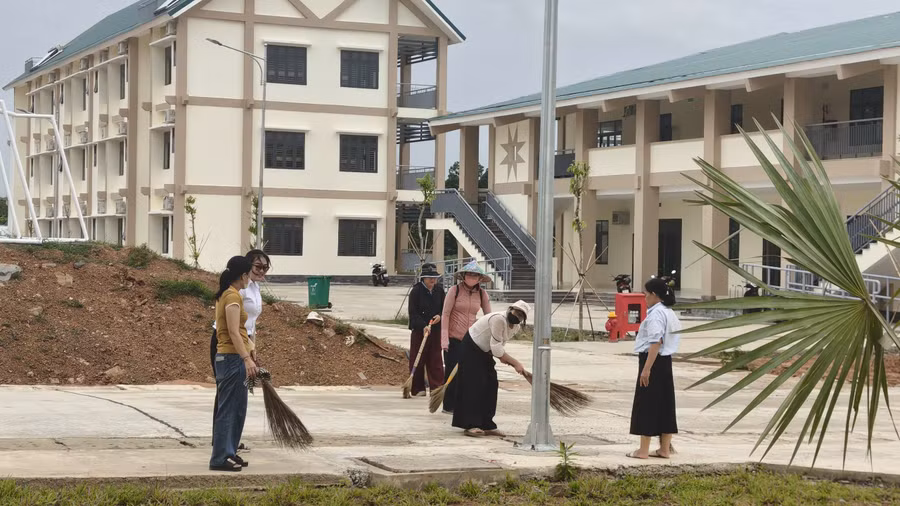Thầy cô tất bật dọn vệ sinh sân trường. (Ảnh: T.H)