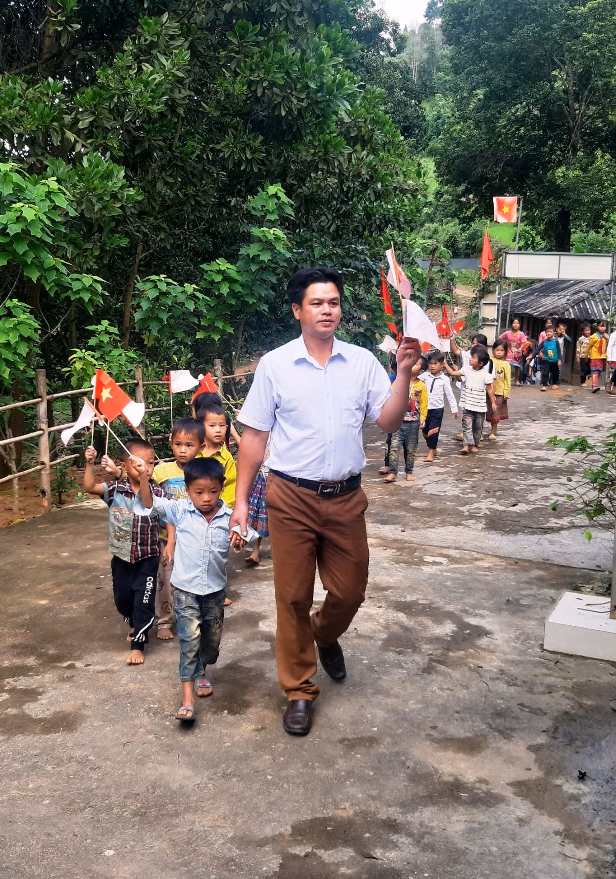 Thầy giáo đón học trò ở điểm lẻ bản Ón, Trường Tiểu học Tam Chung (Mường Lát, Thanh Hóa). Ảnh: NTCC. Thầy giáo đón học trò ở điểm lẻ bản Ón, Trường Tiểu học Tam Chung (Mường Lát, Thanh Hóa). Ảnh: NTCC.