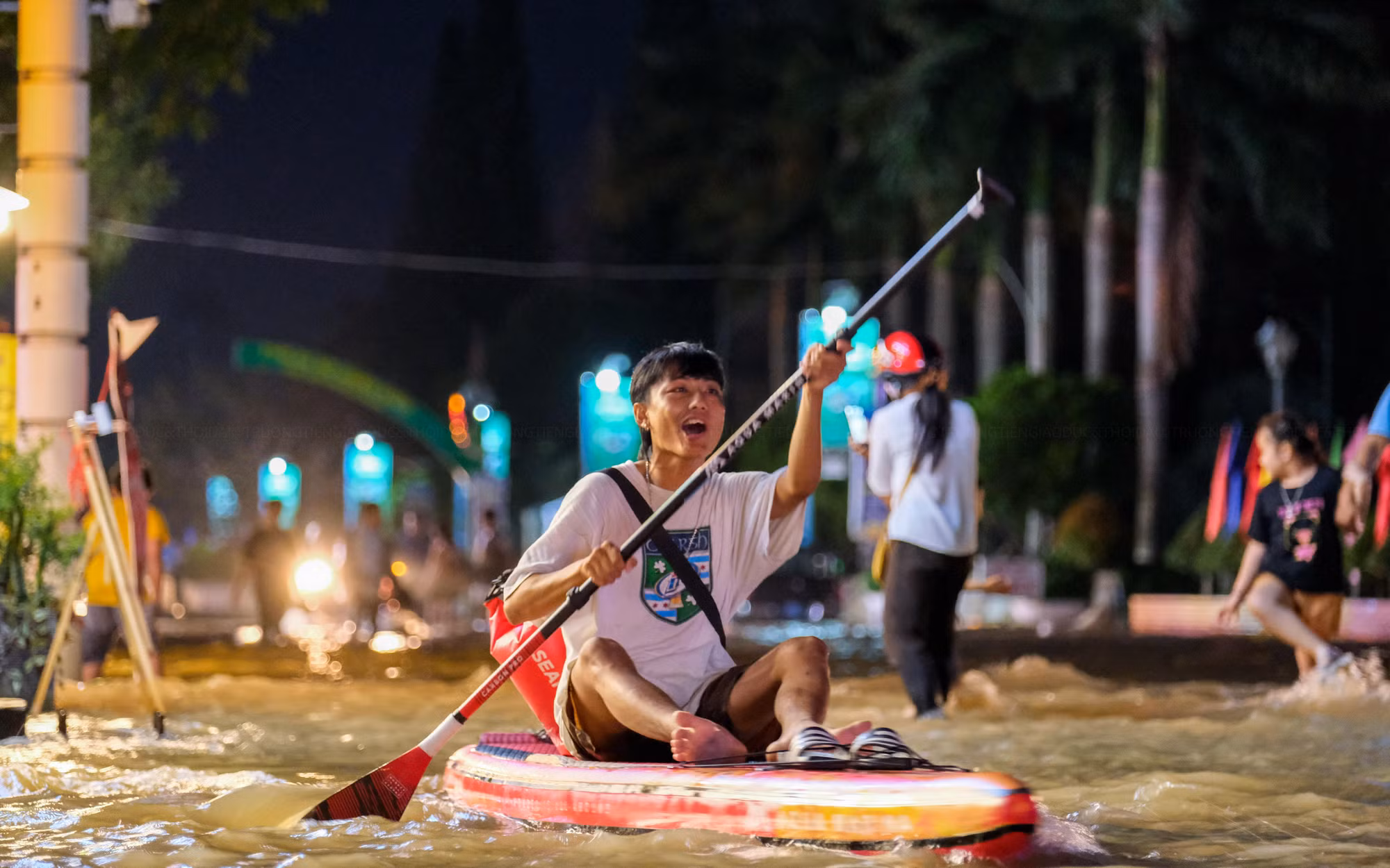 Một nhóm bạn trẻ thích thú chèo thuyền Sup xung quanh các tuyến đường ngập tại bến Ninh Kiều.