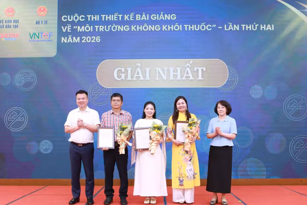 Nhà báo Triệu Ngọc Lâm và bà Phan Thị Hải trao giấy chứng nhận và hoa cho các tác giả đạt giải Nhất.