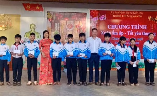 Bà Trần Thị Hồng, Phó Hiệu trưởng Trường THCS Nguyễn Du trao quà tết cho học sinh.