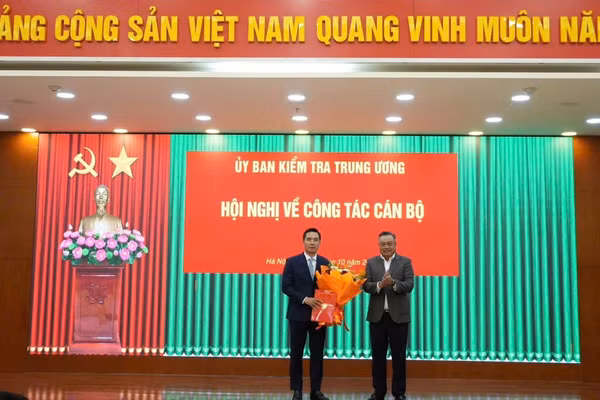 Chủ nhiệm Ủy ban Kiểm tra Trung ương Trần Sỹ Thanh trao quyết định và tặng hoa chúc mừng ông Trần Văn Phúc - Ảnh: UBKT Trung ương