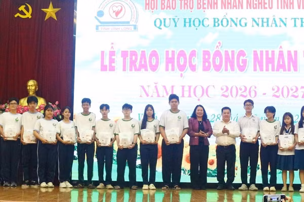 Bà Nguyễn Thị Bé Mười và lãnh đạo Công ty TNHH MTV PETROLIMEX Vĩnh Long trao học bổng cho học sinh.
