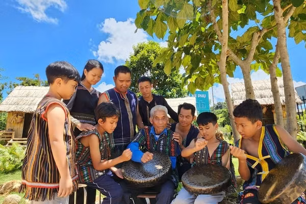 Các nghệ nhân người K'Ho truyền dạy đánh chiêng cho học sinh tại khu du lịch cộng đồng Làng K’Ho Cil. Ảnh: KHC.