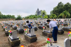 Học sinh Trường TH&THCS Phường 4 (TP Đông Hà) chăm sóc khu mộ các liệt sĩ ở Nghĩa trang Liệt sĩ Quốc gia Đường 9. Ảnh: NTCC
