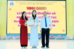 Thầy Hiệu trưởng Lê Phú Hải trao tặng Huy chương Bạc và Giấy khen cho em Lê Võ Uyên Phương. Ảnh: NVCC 