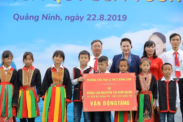 Bà Nguyễn Thị Kim Ngân - Uỷ viên Bộ chính trị, Chủ tịch Quốc hội nước Cộng hoà XHCN Việt Nam trao tặng bảng tượng trưng tặng trường Tiểu học & THCS Đồng Sơn, huyện Hoành Bồ, tỉnh Quảng Ninh cho đại diện lãnh đạo trường và các em học sinh.