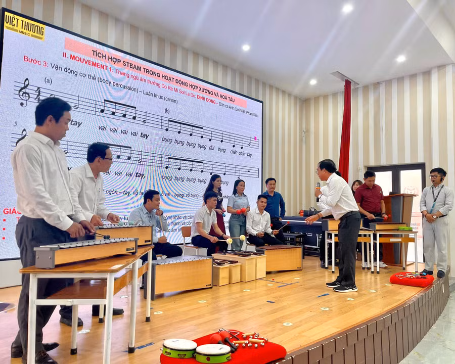 Giáo viên âm nhạc thực hành với các loại nhạc cụ để tổ chức hoạt động hòa tấu đơn giản tại lớp tập huấn. 