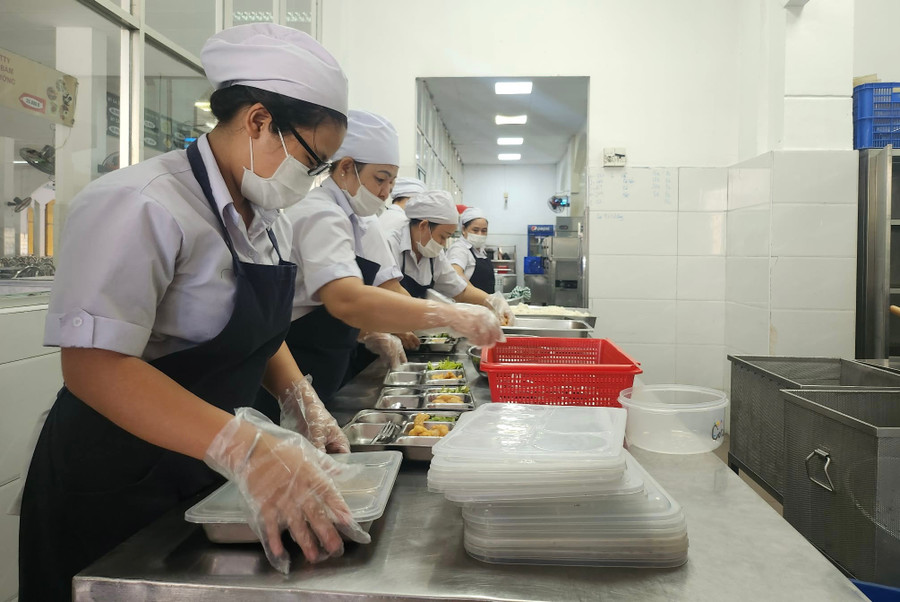 Nhân viên Trường THPT Trung Vương phân chia khẩu phần thức ăn ra từng khay.