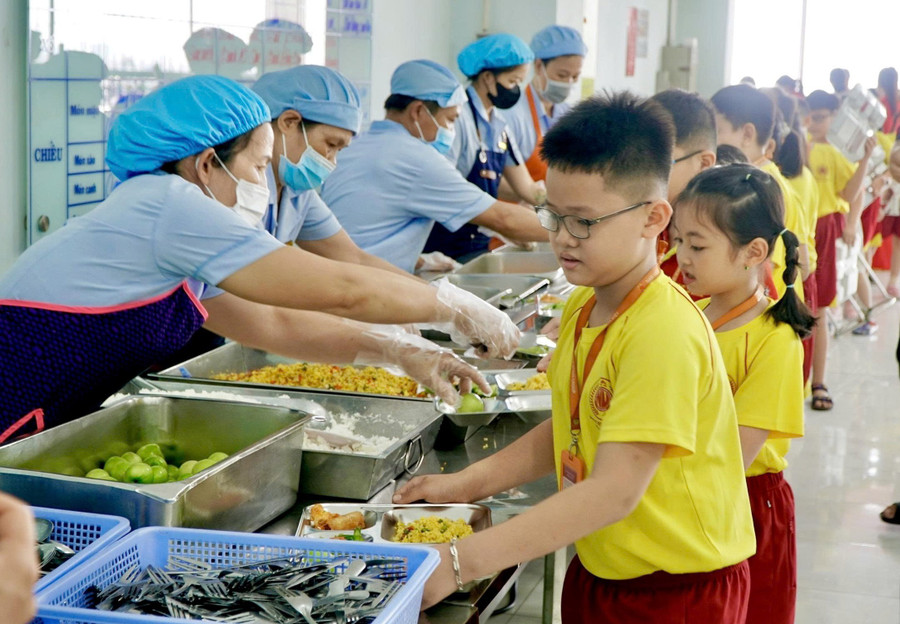 Học sinh Trường Tiểu học, THCS, THPT Nam Việt lấy khẩu phần ăn bán trú. Ảnh: NL.