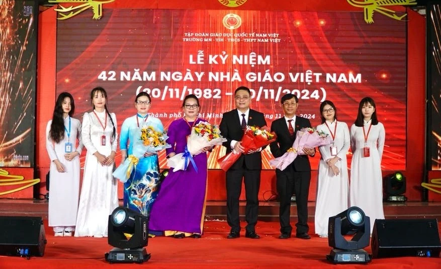 Học sinh Trường MN-TH-THCS-THPT Nam Việt tặng hoa cho Ban Giám hiệu nhà trường.