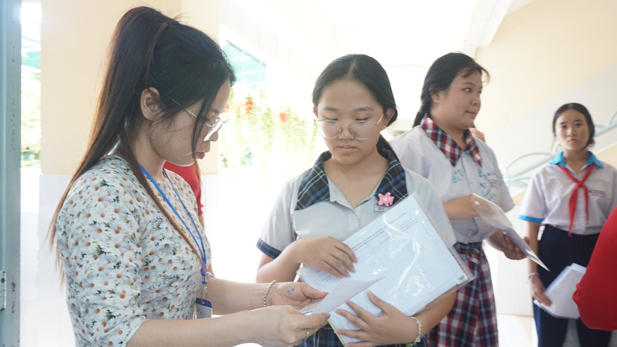 Giám thị tại điểm thi Trường THCS Nguyễn Trãi kiểm tra thông tin thí sinh trước khi vào phòng thi. thi-tuyen-sinh-lop-10-mon-ngoai-ngu-lop-10.jpg