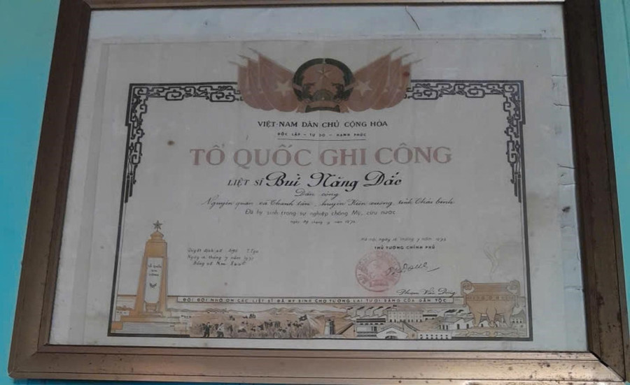Tấm bằng Tổ quốc ghi công của liệt sĩ Bùi Năng Đắc được treo trang trọng tại quê nhà. (Ảnh: Gia đình cung cấp) tt-269-4.jpg