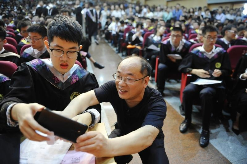 Người cha chuẩn bị ghi lại khoảnh khắc con trai đọc diễn văn trong lễ tốt nghiệp tại Đại học Khoa học và Kỹ thuật Trung Quốc. Ảnh: China Daily. Người cha chuẩn bị ghi lại khoảnh khắc con trai đọc diễn văn trong lễ tốt nghiệp tại Đại học Khoa học và Kỹ thuật Trung Quốc. Ảnh: China Daily.