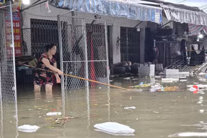 Tiểu thương chợ Vinh di dời hàng hóa đến nơi khô ráo. (Ảnh: Phạm Tâm)