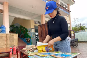 Giáo viên lựa những quyển sách còn sử dụng được phơi khô để học sinh học tập.