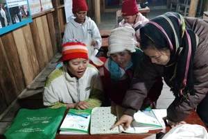 Giáo viên Trường Phổ thông Dân tộc Bán trú cấp 1, 2 Măng Bút 2 hướng dẫn người dân đọc, viết.