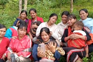 Người dân tranh thủ thời gian trên rẫy xem bài học trên kênh "Bình dân học vụ".