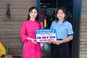 Cô giáo Hoàng Thị Diệu Loan trao phần quà của nhà hảo tâm hỗ trợ cho em Siu H’Suyn.