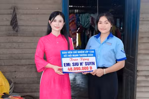 Cô giáo Hoàng Thị Diệu Loan trao phần quà của nhà hảo tâm hỗ trợ cho em Siu H’Suyn.