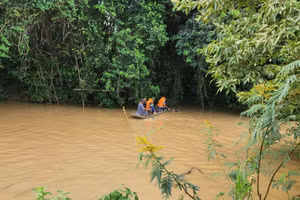Lực lượng chức năng tìm kiếm 2 chị em bị nước cuốn trôi.
