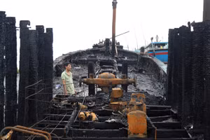 Đứng giữa xác tàu cháy đen, người ngư dân lặng người trước mất mát quá lớn.