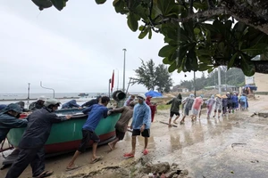 Lực lượng chức năng cùng người dân di dời tàu thuyền đến nơi an toàn.