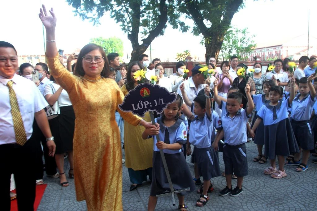 Thầy cô giáo dắt học sinh khối 1 vào trường.