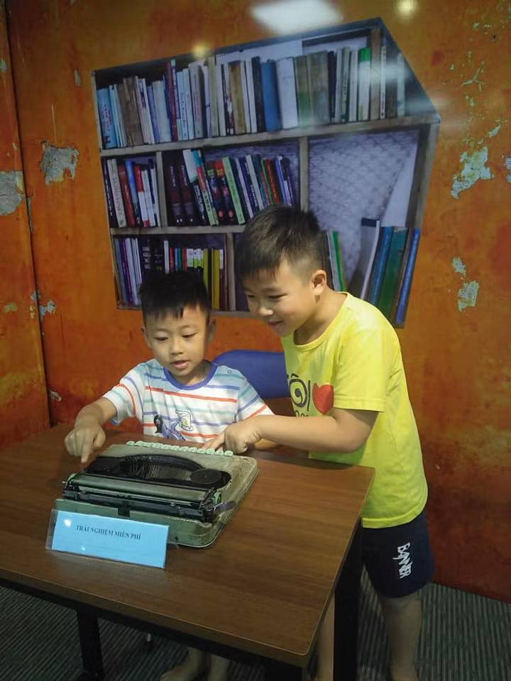 Các em nhỏ được trải nghiệm với chiếc máy đánh chữ.