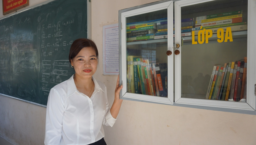Cô giáo Lê Thị Hải bên tủ sách lớp học (ảnh Trịnh Huyền)